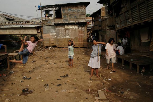 Outside school hours, young girls enjoy hanging out playing a jumping rope game ciliwung04.jpg